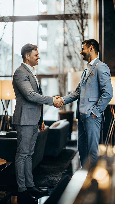 two men in suits shaking hands